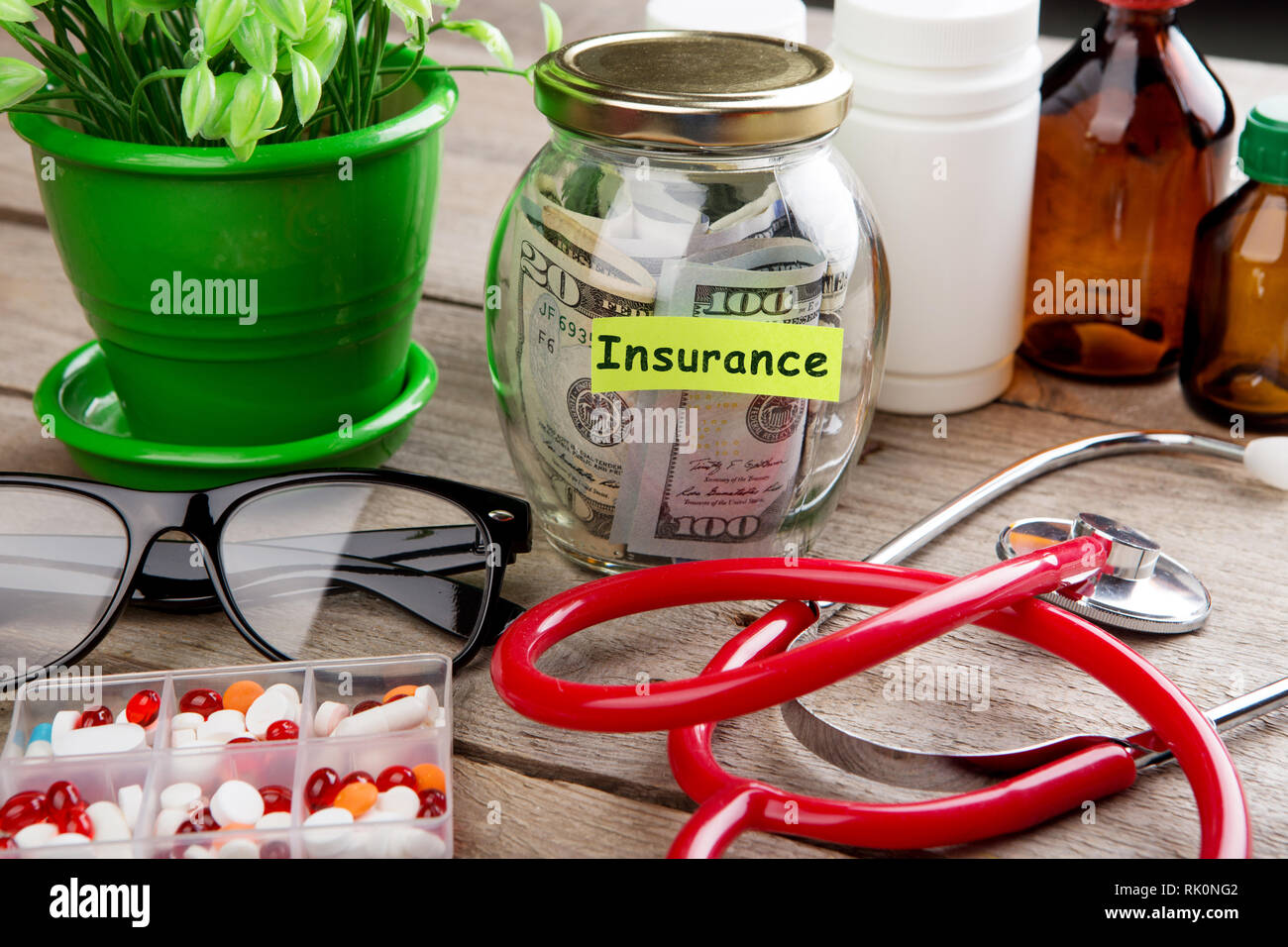 Saving money for health care insurance - money glass, stethoscope, pills and bottles Stock Photo