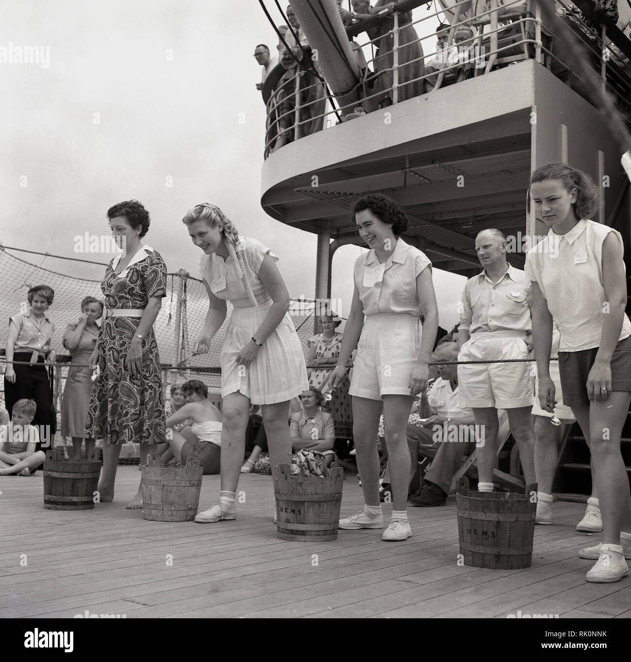 1950s, historical, female passengers with small wooden barrels beside them taking part a deck game onboard a Union-Caste steamship. Stock Photo