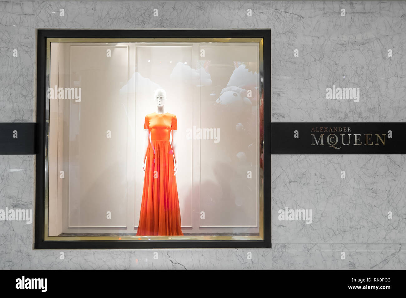HONG KONG - 23 JAN, 2015: Alexander Mcqueen fashion boutique display window with mannequin dressed in haute couture luxury red female dress Stock Photo
