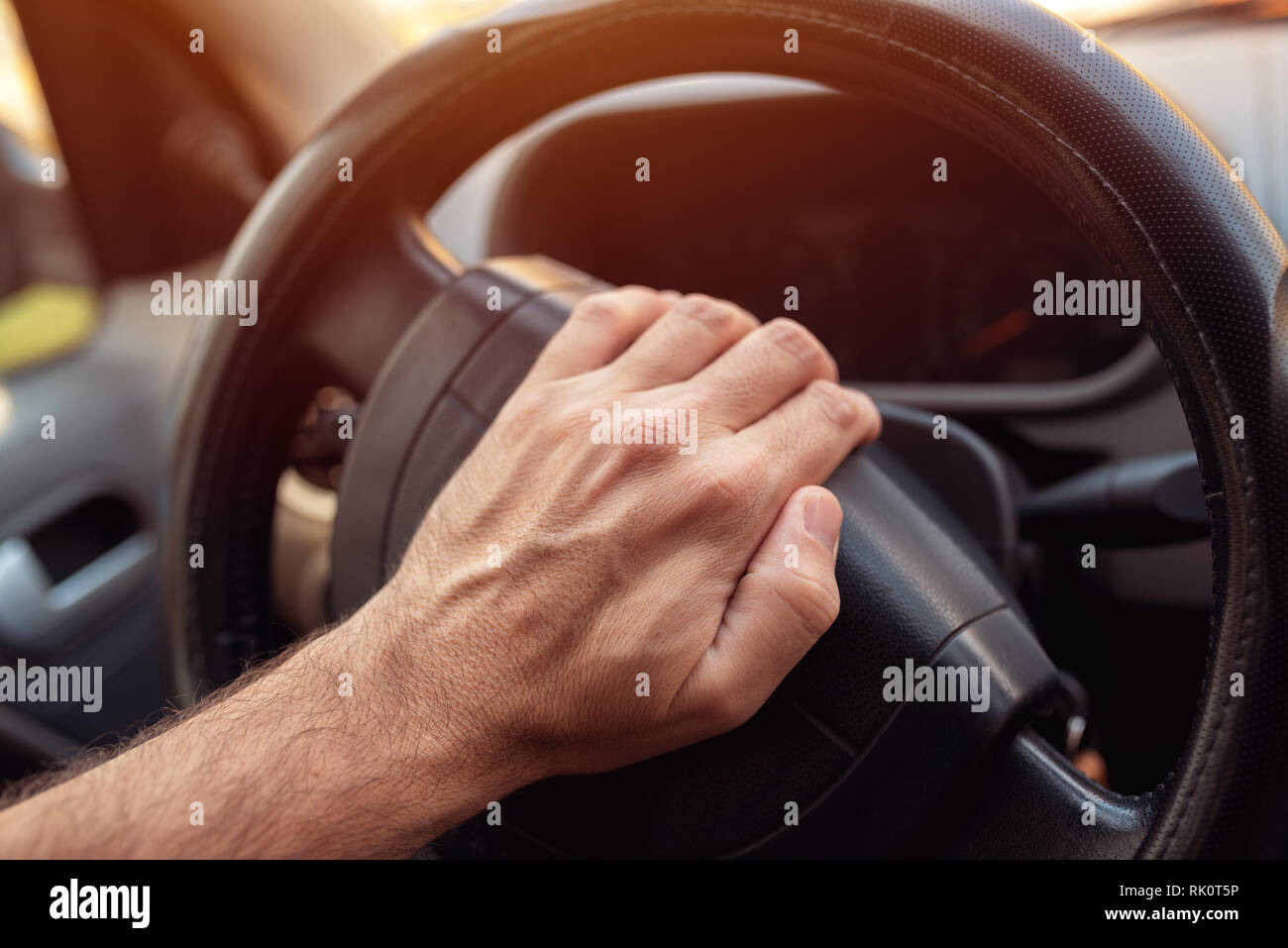 Nervous driver pushing car horn on steering wheel Stock Photo