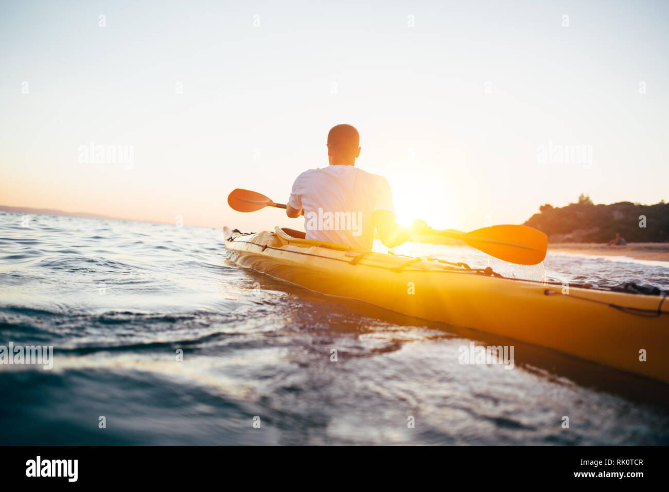 Paddling the canoe at sunset Stock Photo Alamy