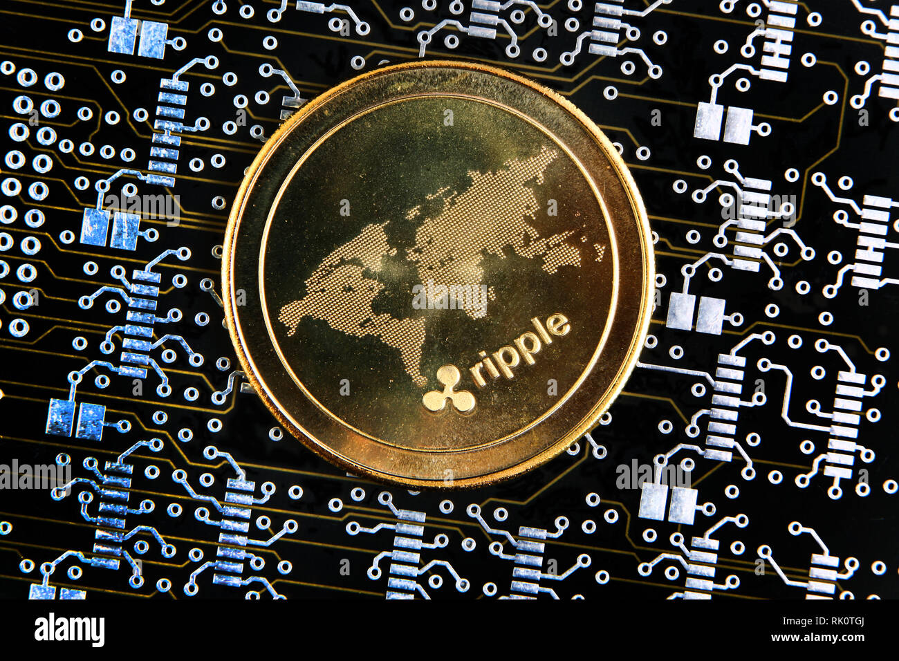 XRP or Ripple gold coin representing cryptocurrencies, against a computer circuit background. Stock Photo