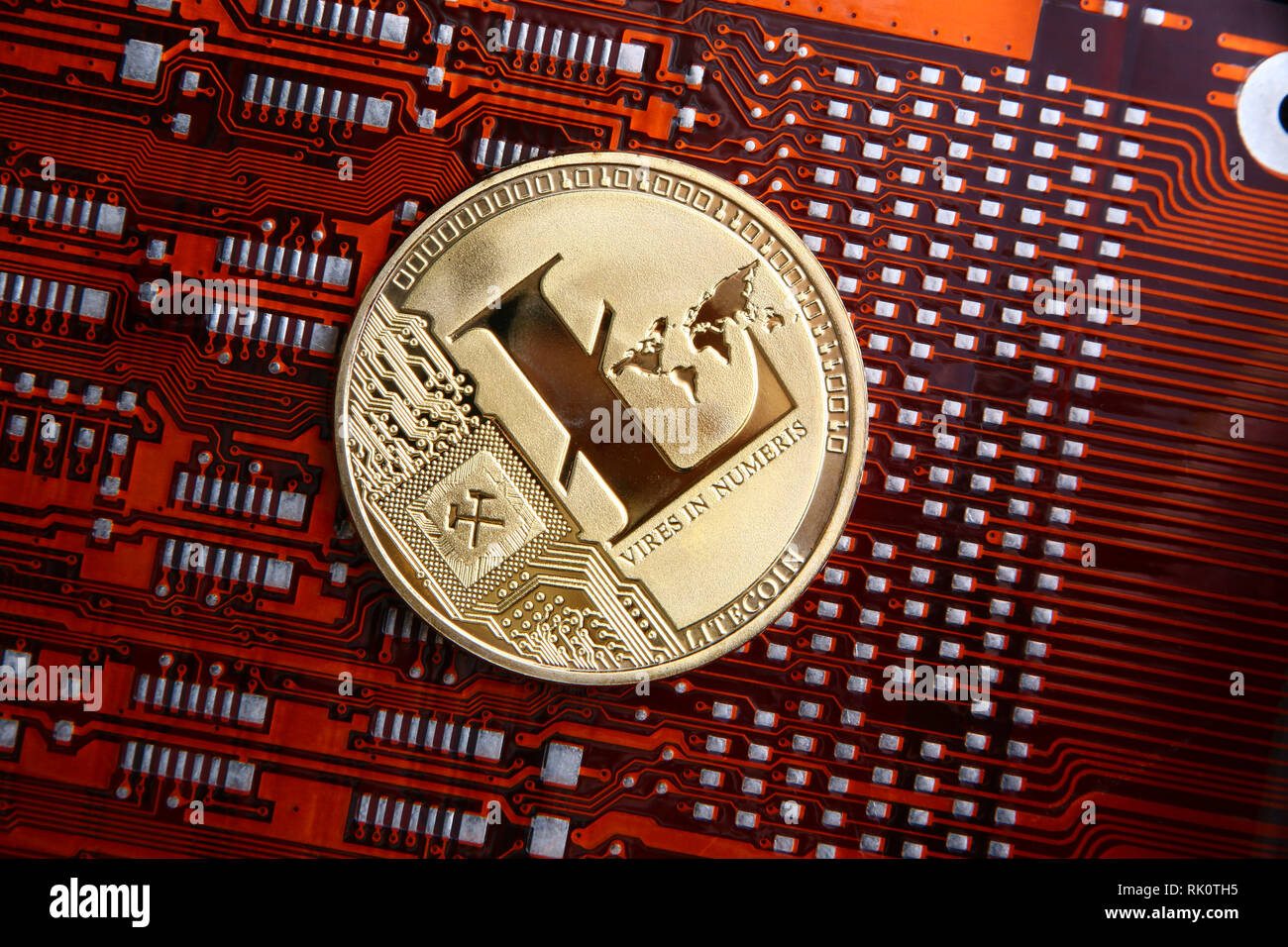 Litecoin gold coin on a orange or red & black computer flexible circuit. Stock Photo