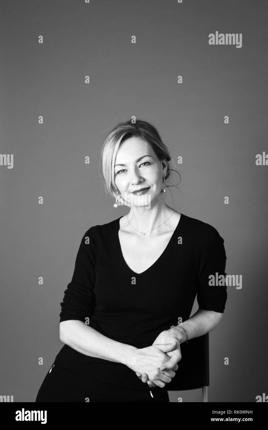 Portrait of beautiful woman in a black dress against grey background ...