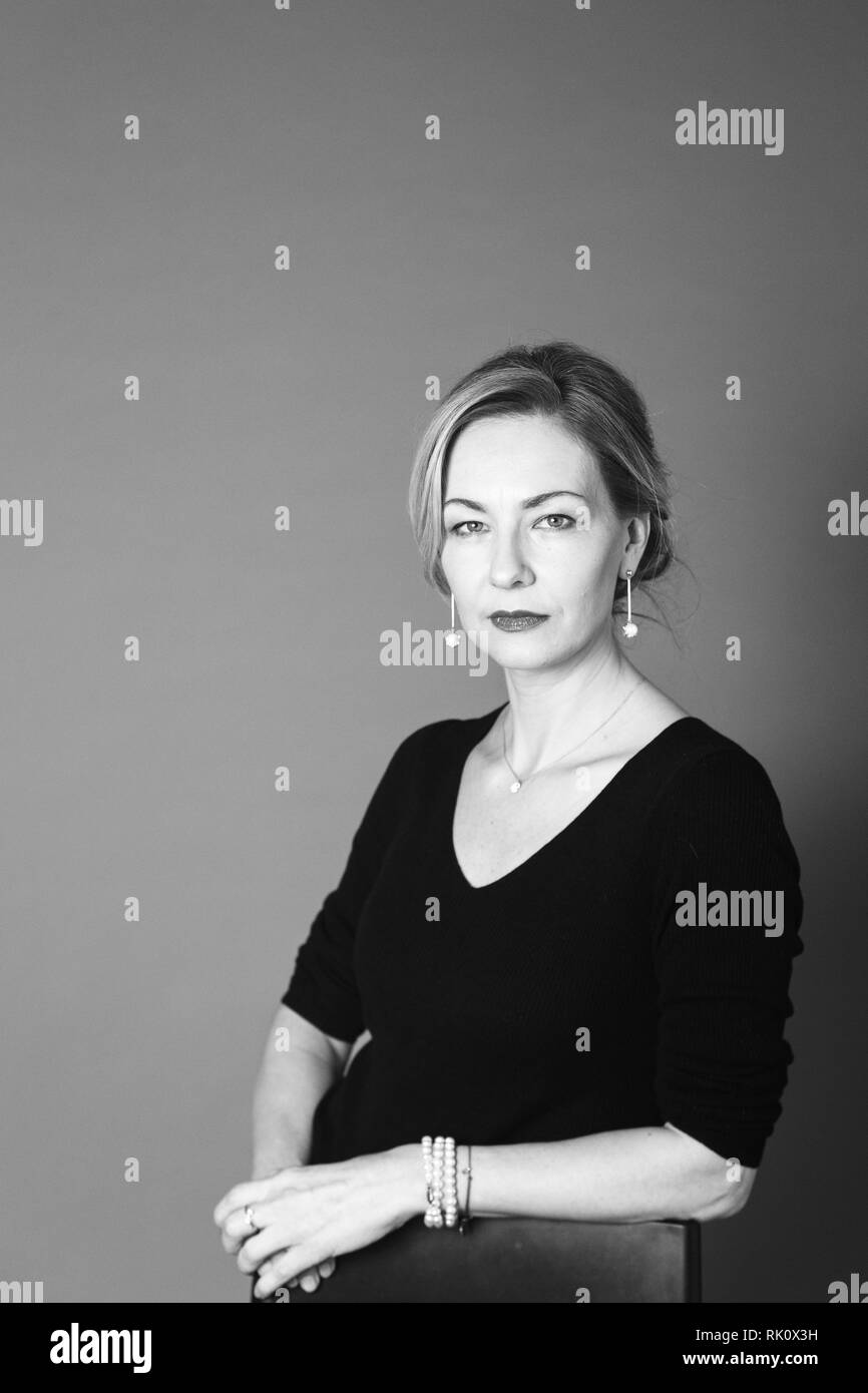Portrait of beautiful woman in a black dress against grey background ...
