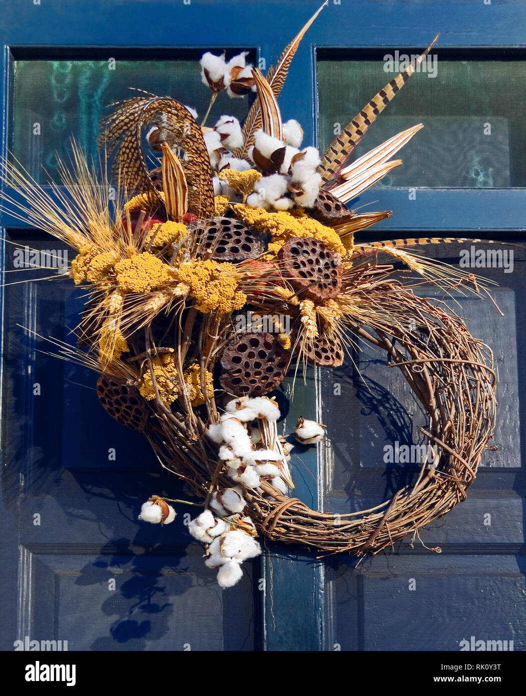 grapevine wreath; natural materials; black door; cotton; feathers; lotus pods; flowers; wheat; unique design, autumn colors, decoration, festive; vert Stock Photo