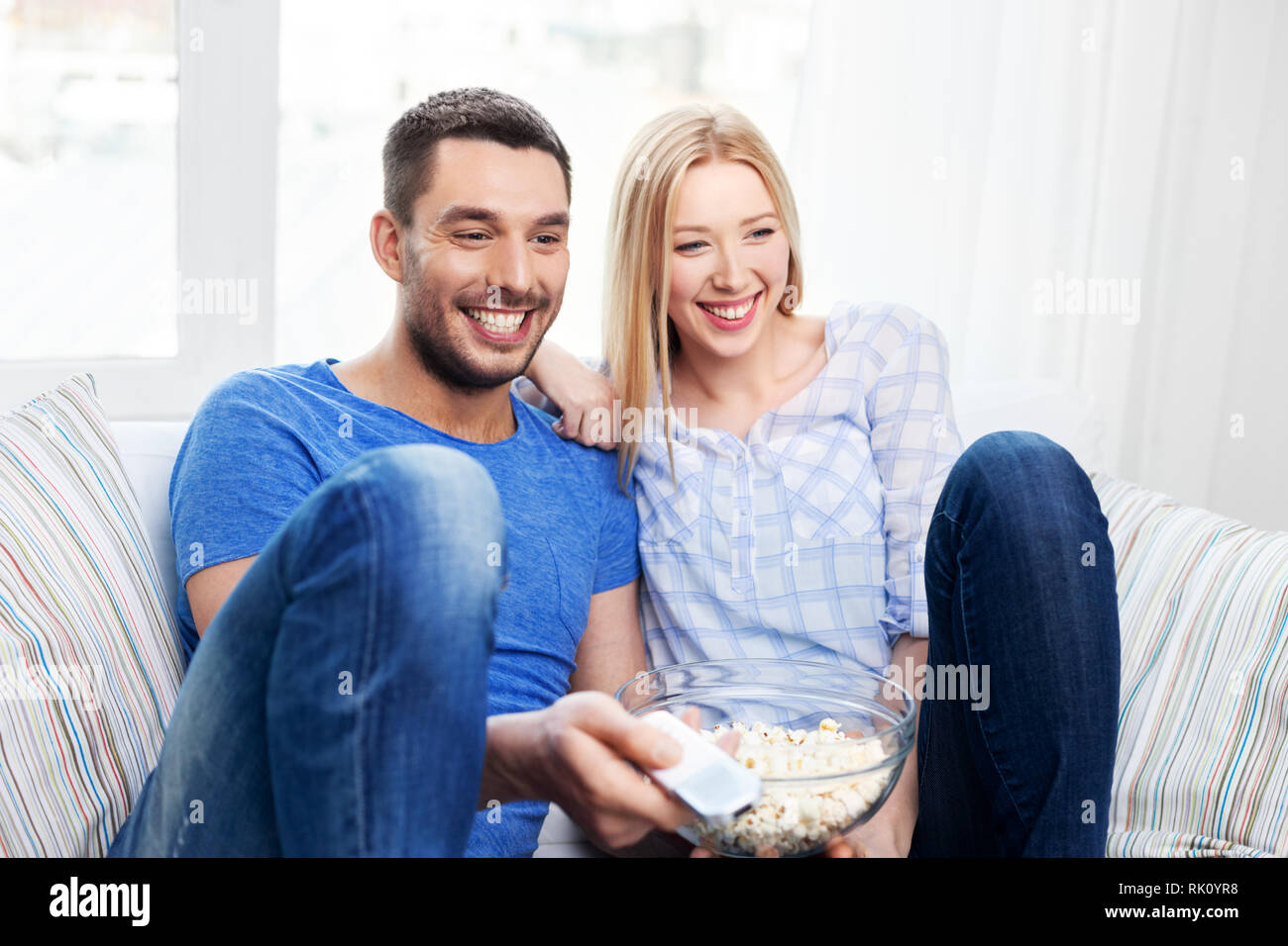 happy couple with popcorn watching tv at home Stock Photo - Alamy