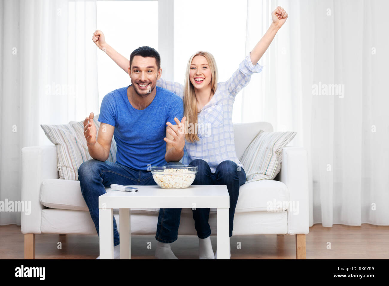 happy couple with popcorn watching tv at home Stock Photo - Alamy