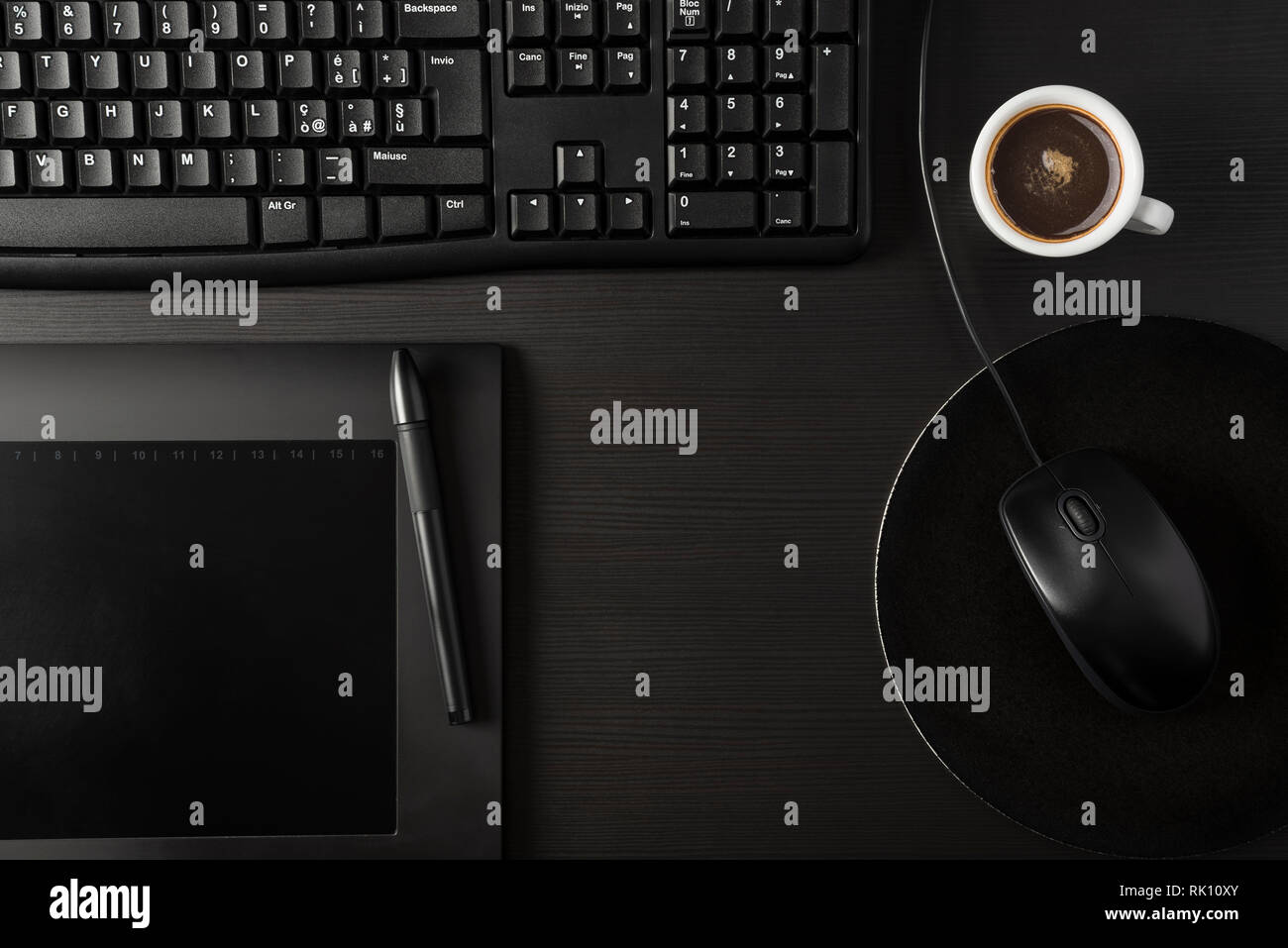 Total black desk with pc, tablet and cup of coffee Stock Photo