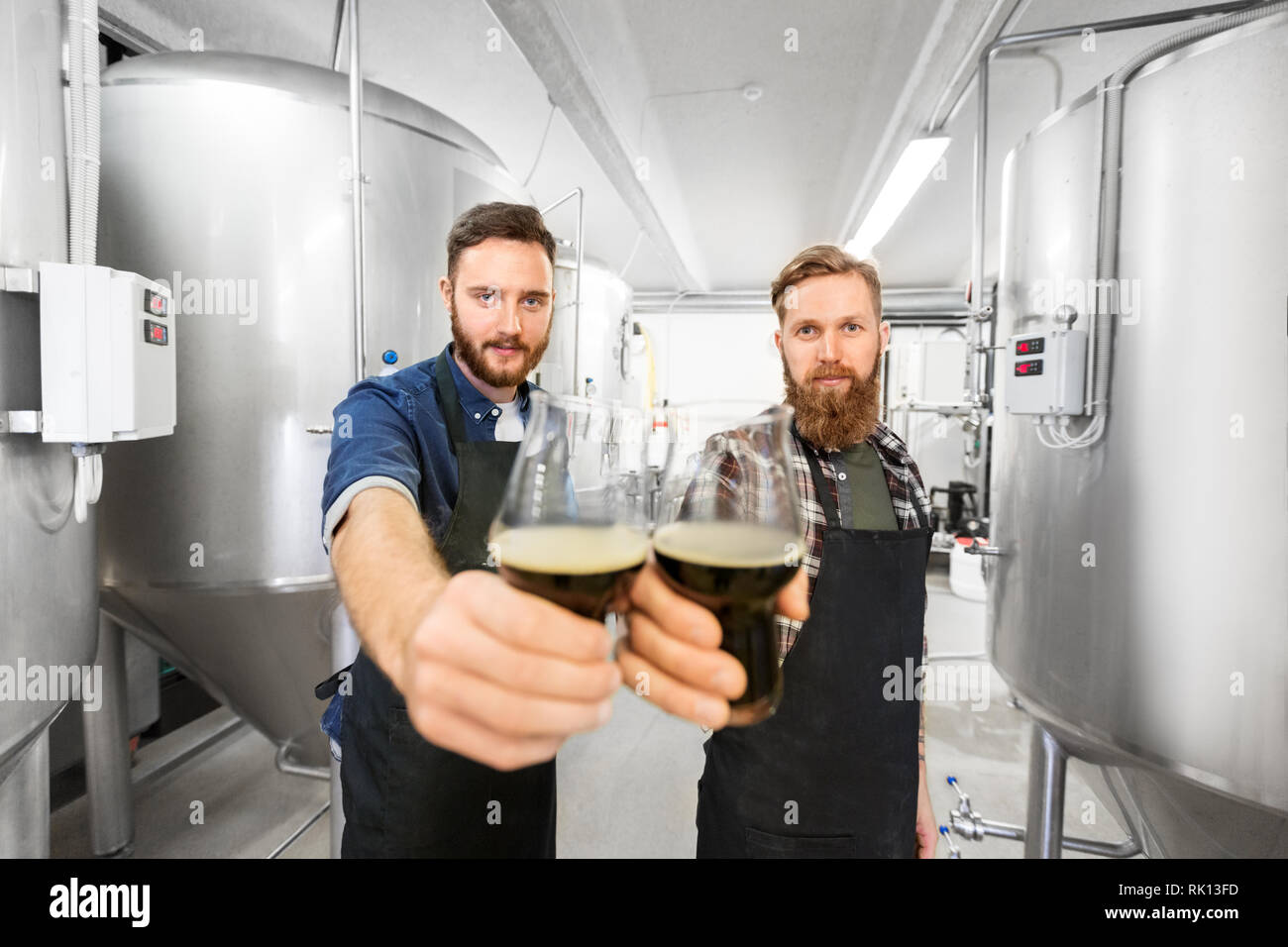 https://c8.alamy.com/comp/RK13FD/brewers-clinking-glasses-of-craft-beer-at-brewery-RK13FD.jpg