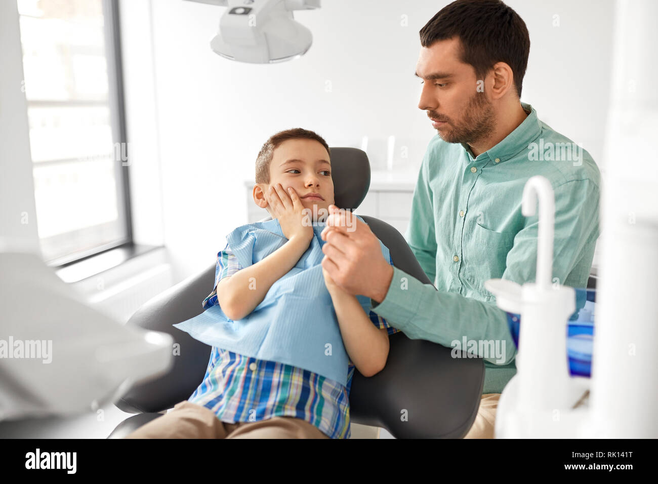 father supporting son at dental clinic Stock Photo