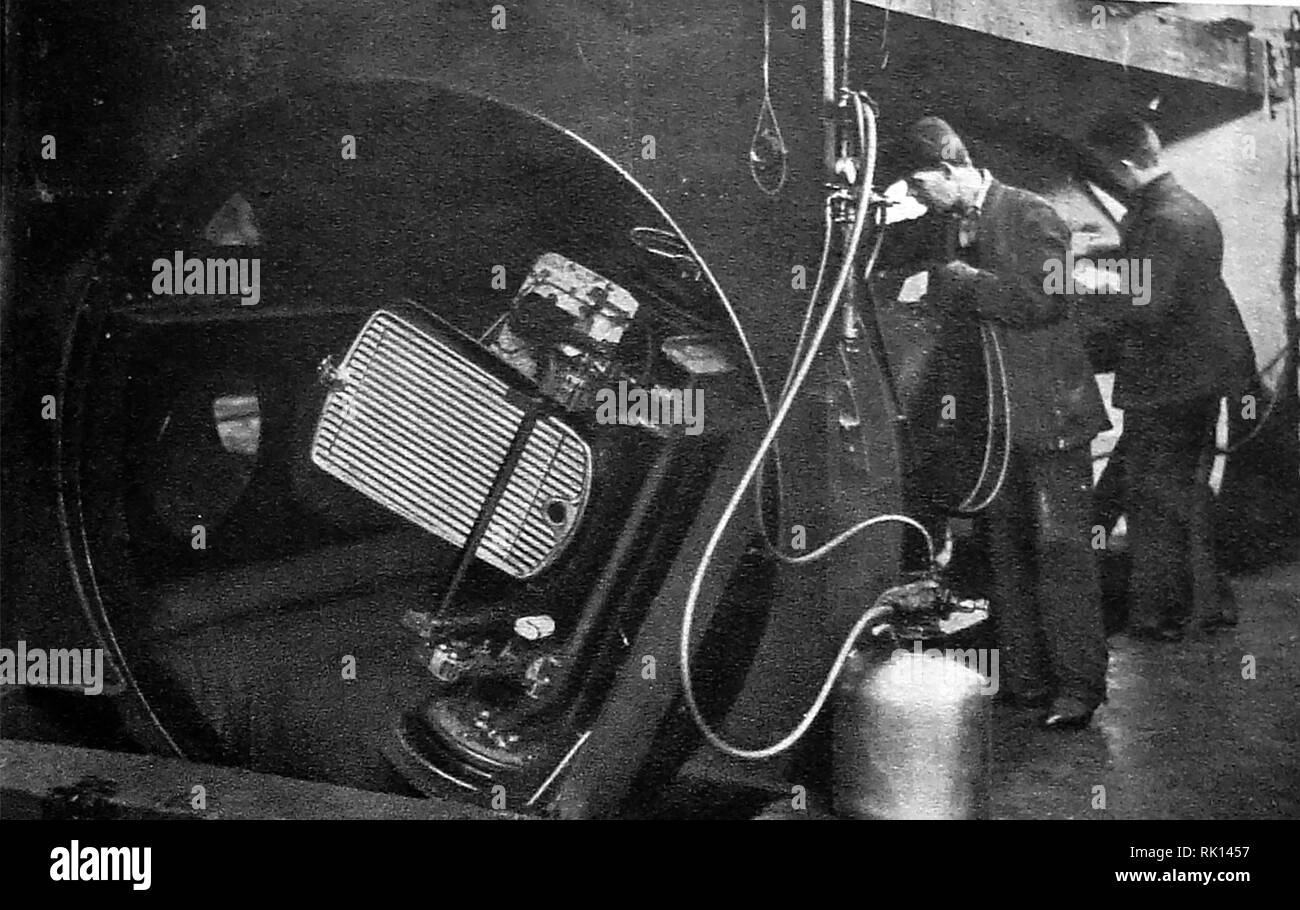 1930 - A look at Morris Motor car production in the UK. Staff spray painting motor cars using a rotary sprayer. Stock Photo