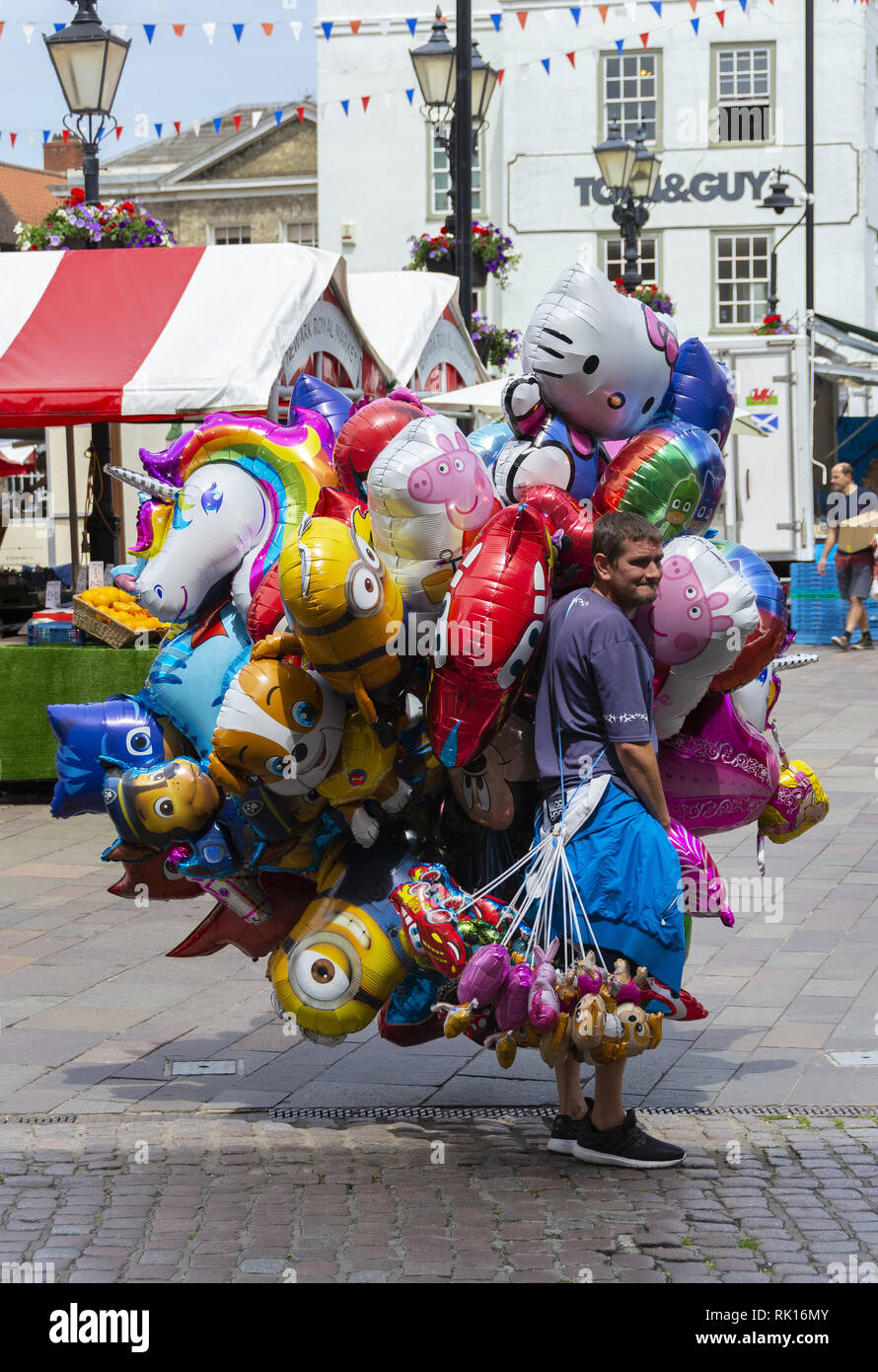 Man selling balloons in Newark Royal Market, Newark, Nottinghamshire, England, UK Stock Photo