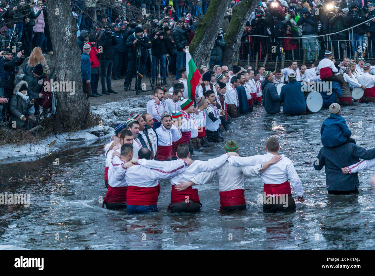 KALOFER, BULGARIA - JANUARY 06, 2019 - Traditional Bulgarian horo dance in the cold icy waters of Tundzha river in Kalofer city Bulgaria. Stock Photo