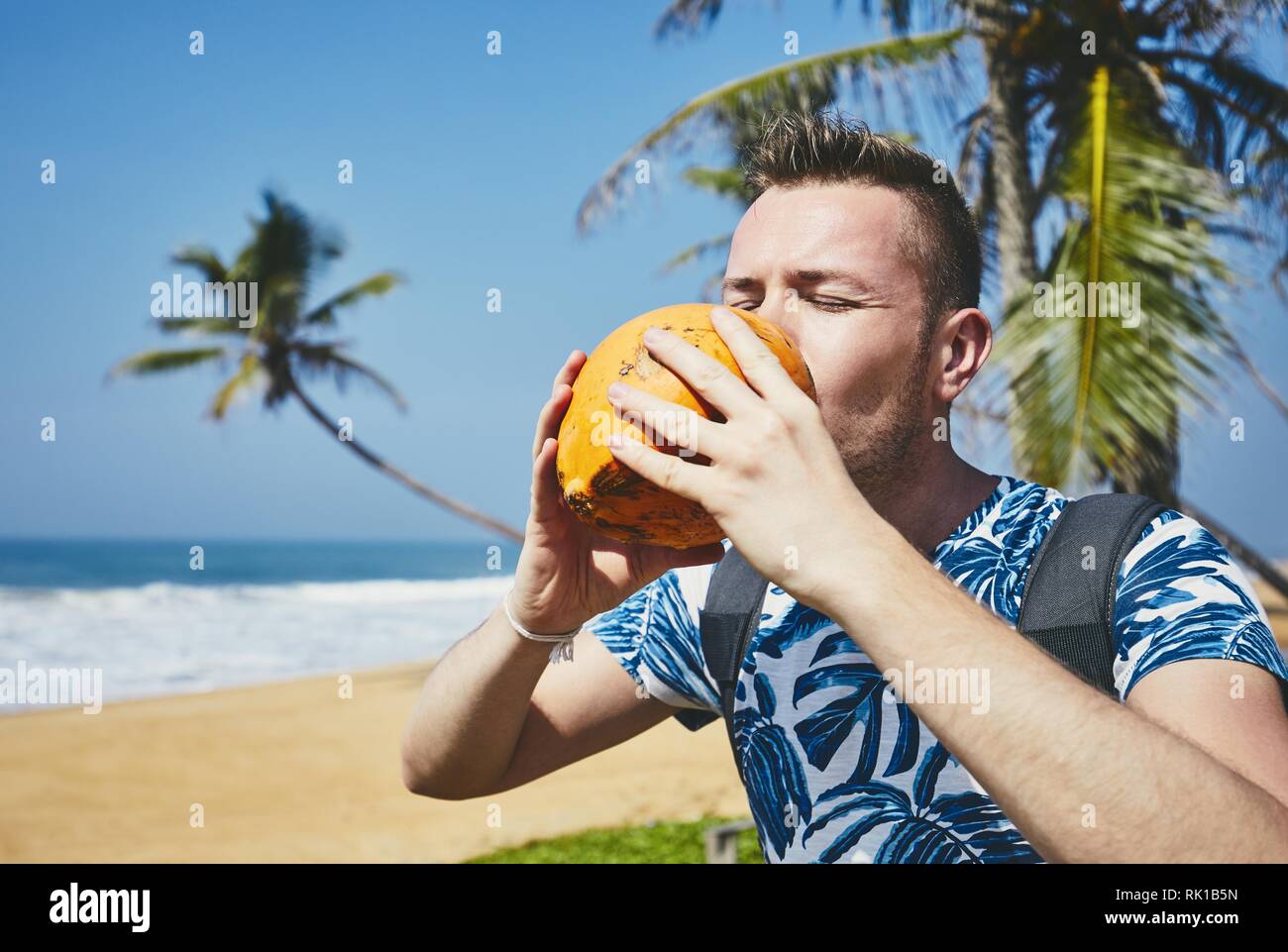 Hand holding coconut on beach hires stock photography and images Alamy