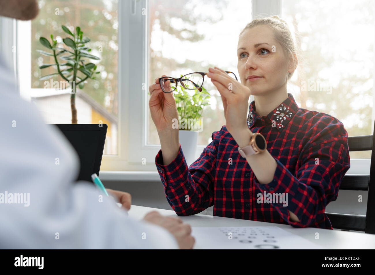 eye care - woman testing her new eyeglasses in optometrist office Stock Photo