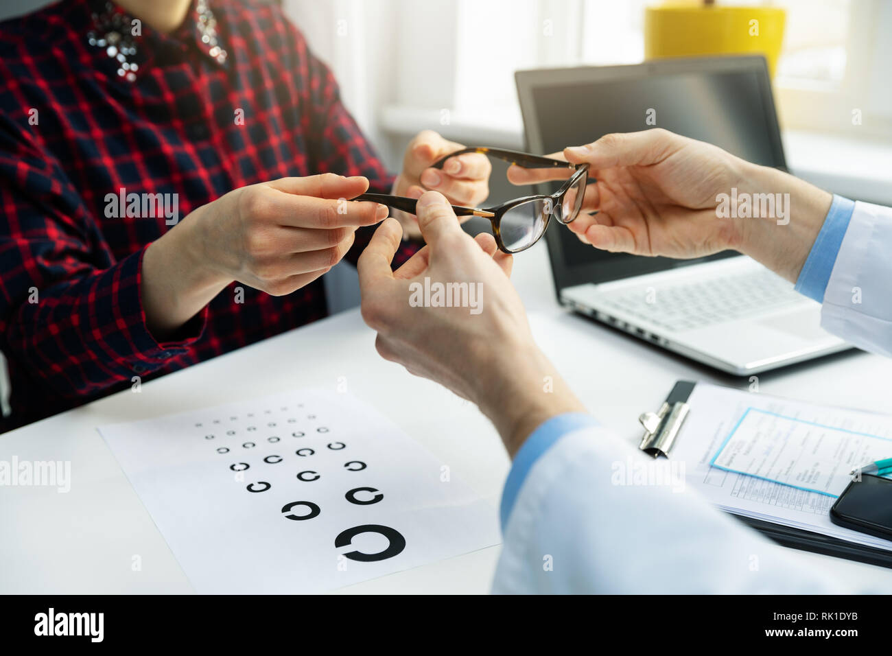 optometrist visit - woman get her new glasses at optician office Stock Photo