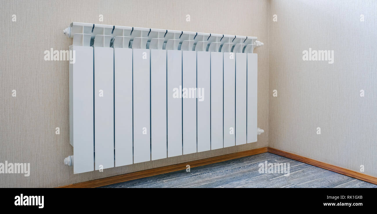 Radiator heating, white radiator in the apartment. Hand felt the