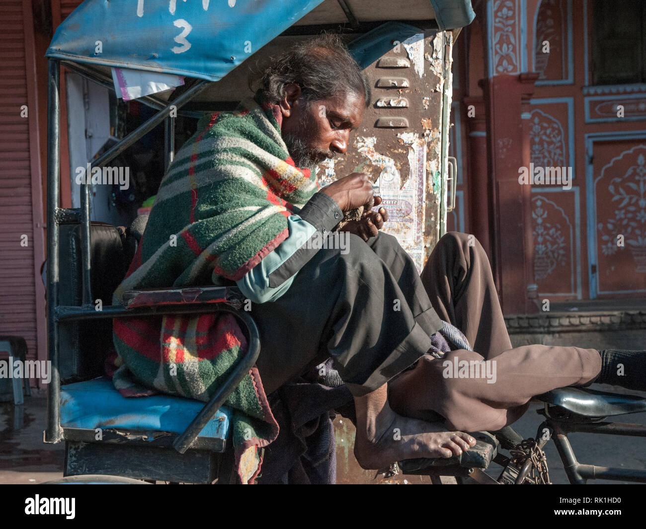 Rickshaw driver waiting for customers in Jaipur in Rajasthan, India. Jaipur is the largest city in Rajasthan with a population of 3-4 million. Stock Photo