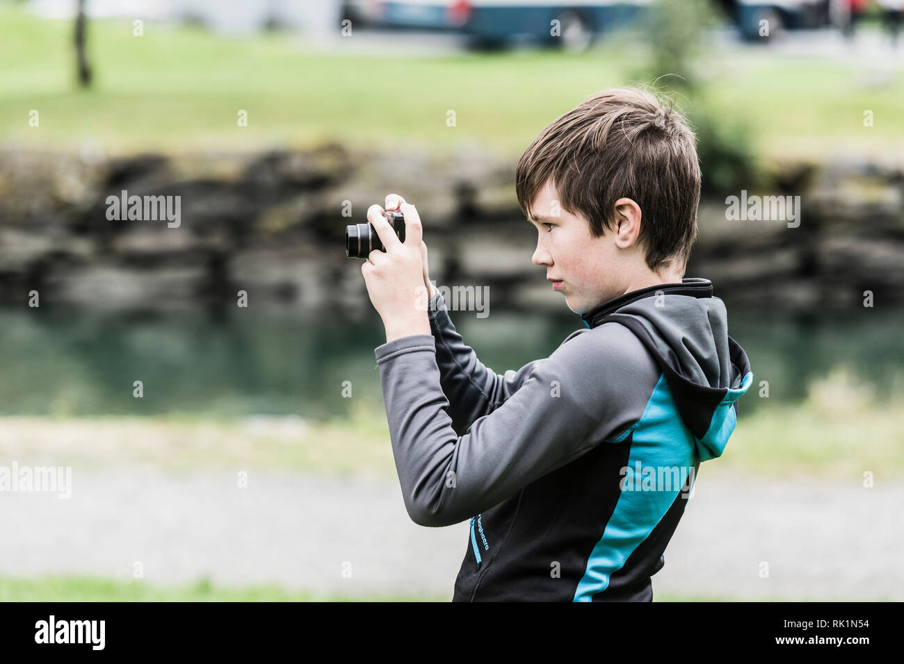 Young boy looking through lens of digital camera, creativity and focus Stock Photo
