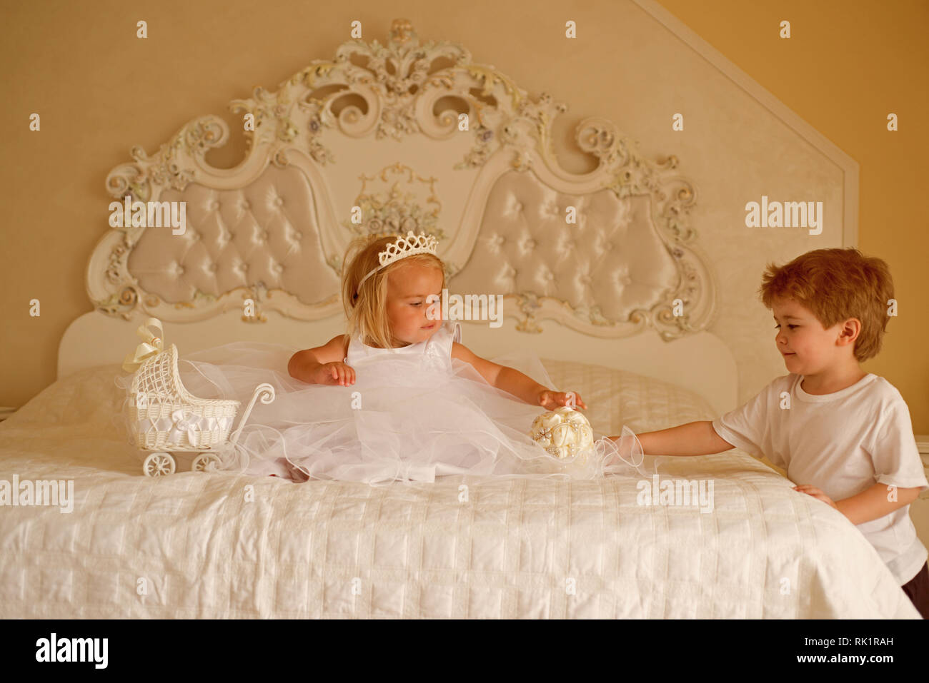 Make this hairstyle a standout. Little flower girl wear hair tiara. Page  boy with blonde hairstyle hold wedding bunch. Little children ready for  Stock Photo - Alamy