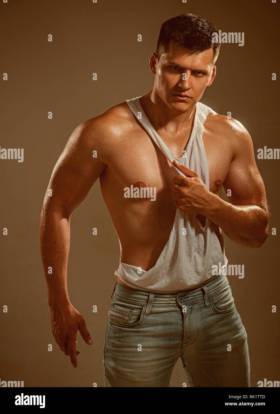 Man wearing white sleeveless shirt on grey background Stock Photo Alamy