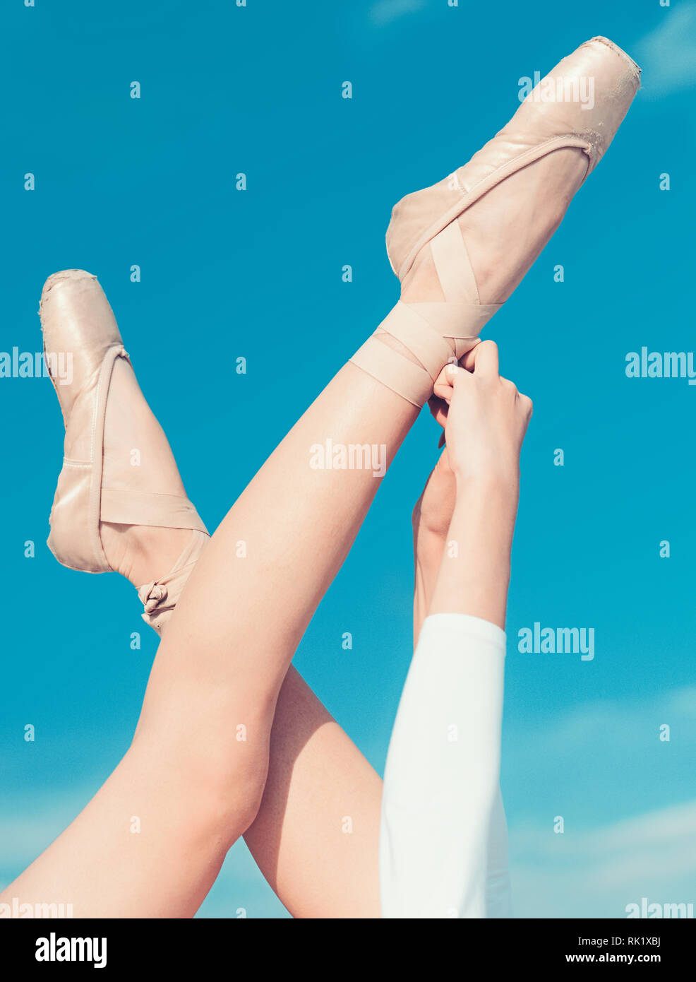 Touching the sky. Pointe shoes worn by ballet dancer. Ballet slippers. Ballerina shoes. Ballerina legs in ballet shoes. Female feet in pointe shoes Stock Photo