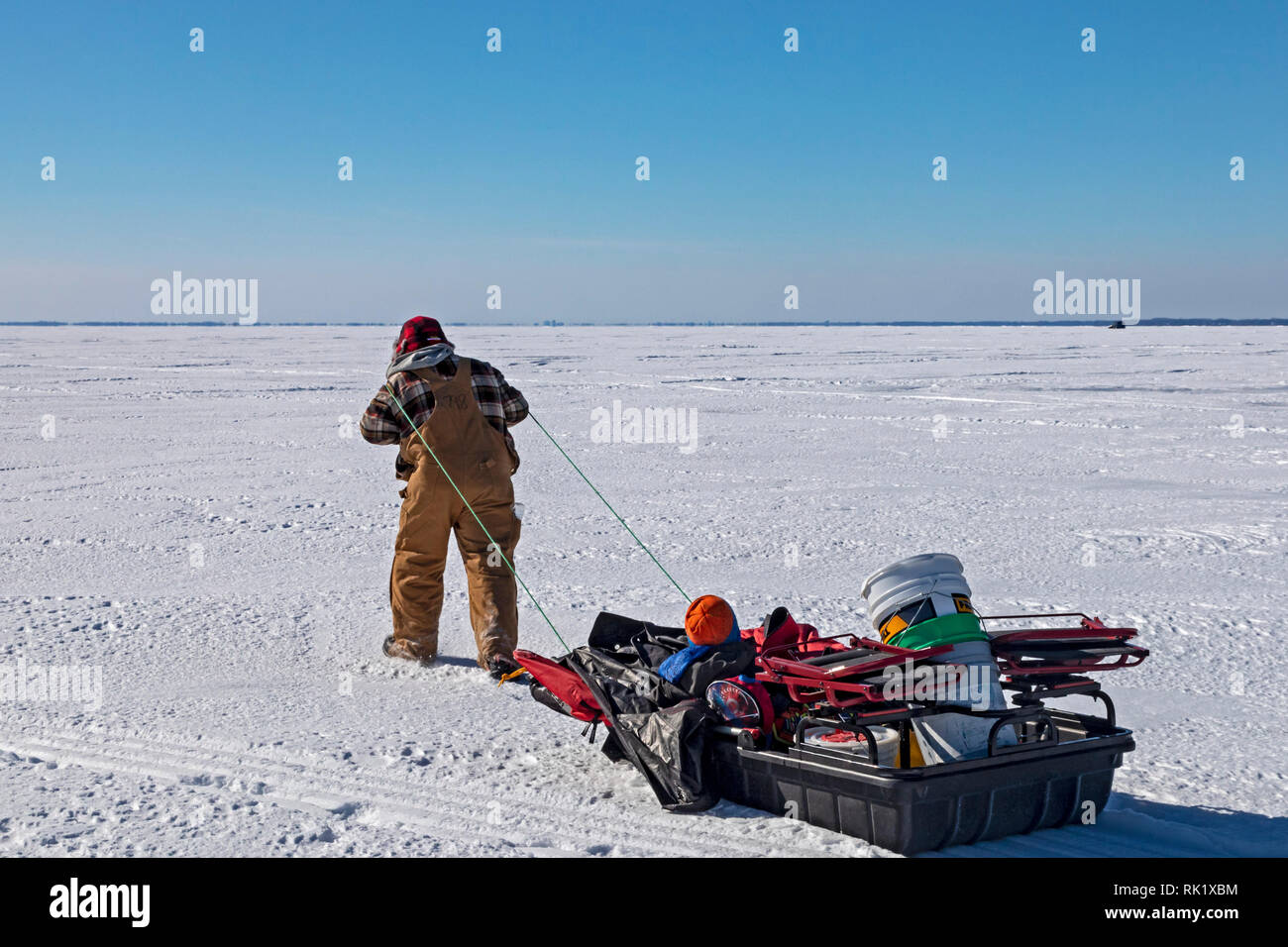 Fair Haven, Michigan An ice fisherman hauls fishing gear and a small