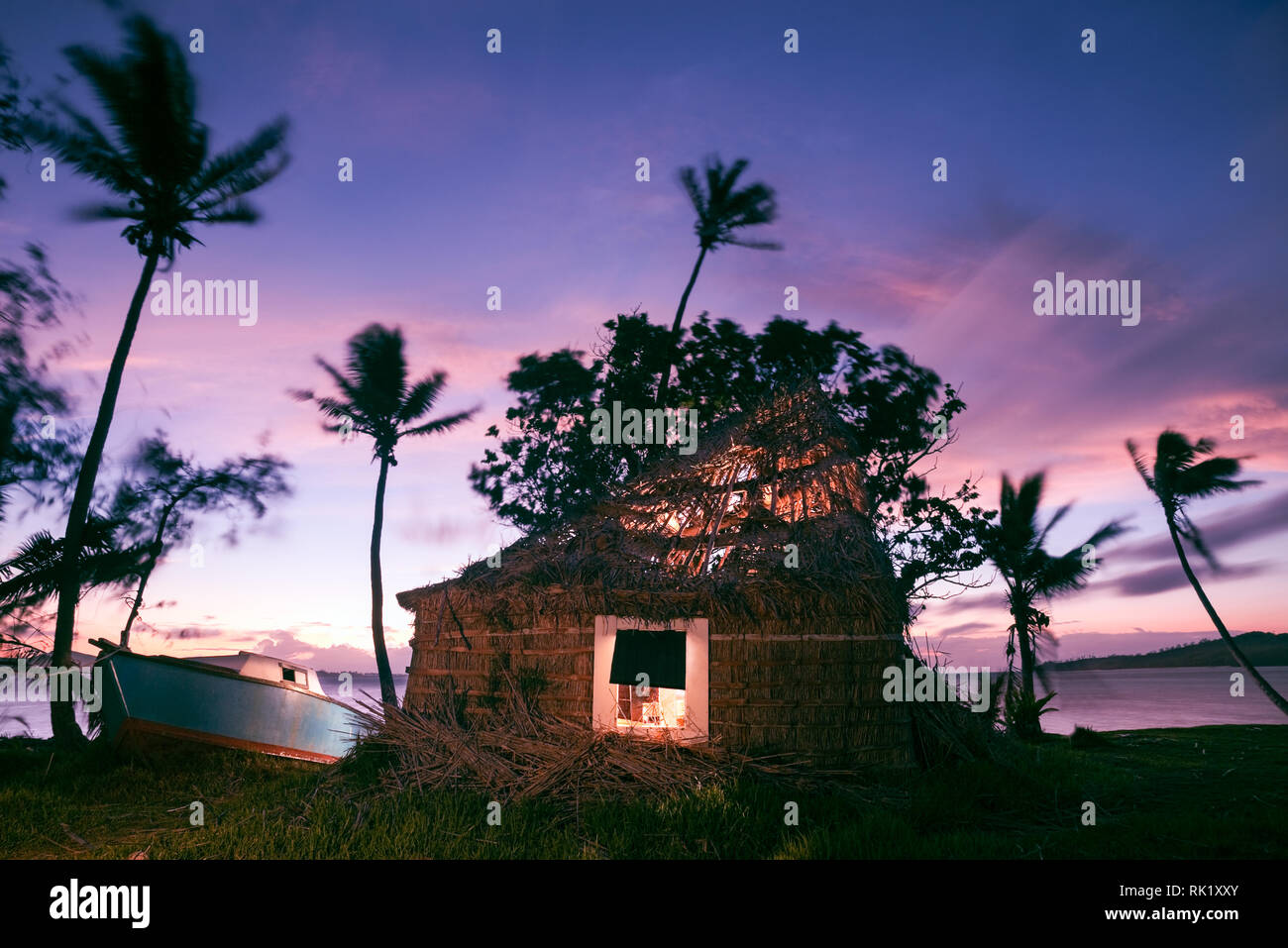 Tavewa Island, Fiji; traditional bure (hut) with broken roof at dawn Stock Photo