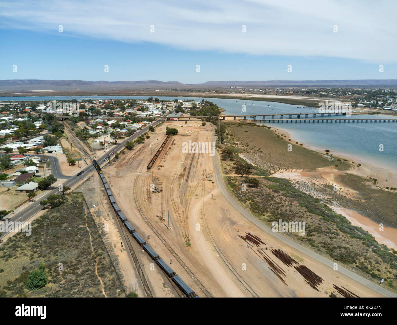 Aerial of freight train leaving Spencer Junction Rail Yard Port Augusta South Australia Stock