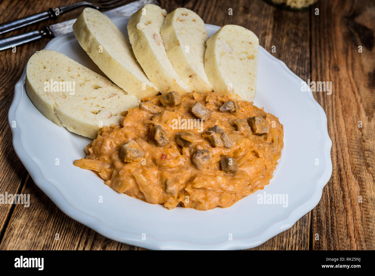 Traditional hungarian goulash (szeged gulyasz),  with pork and pickled white sauerkraut and dumplings on wood table Stock Photo