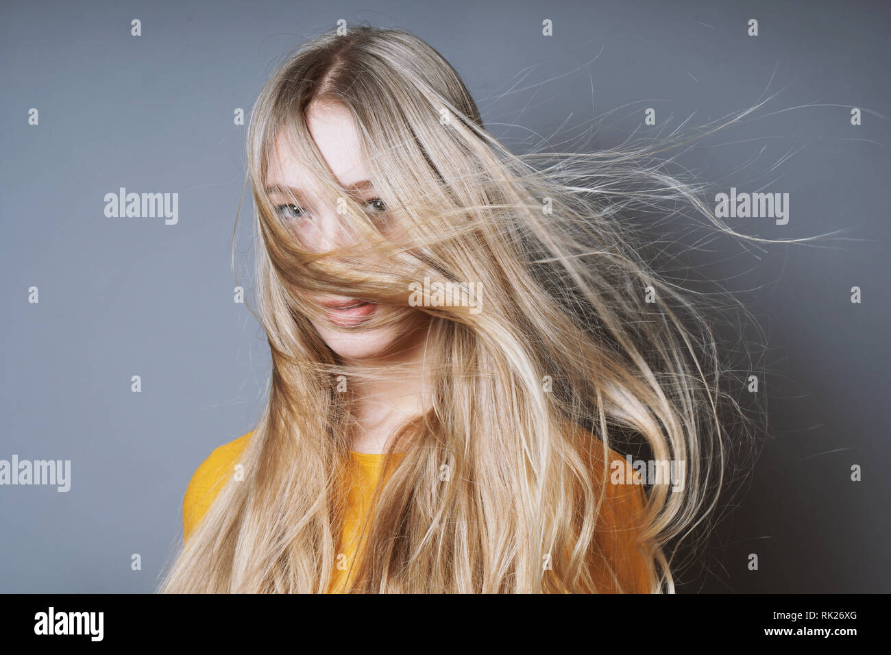 blond woman with long windswept tousled hair Stock Photo