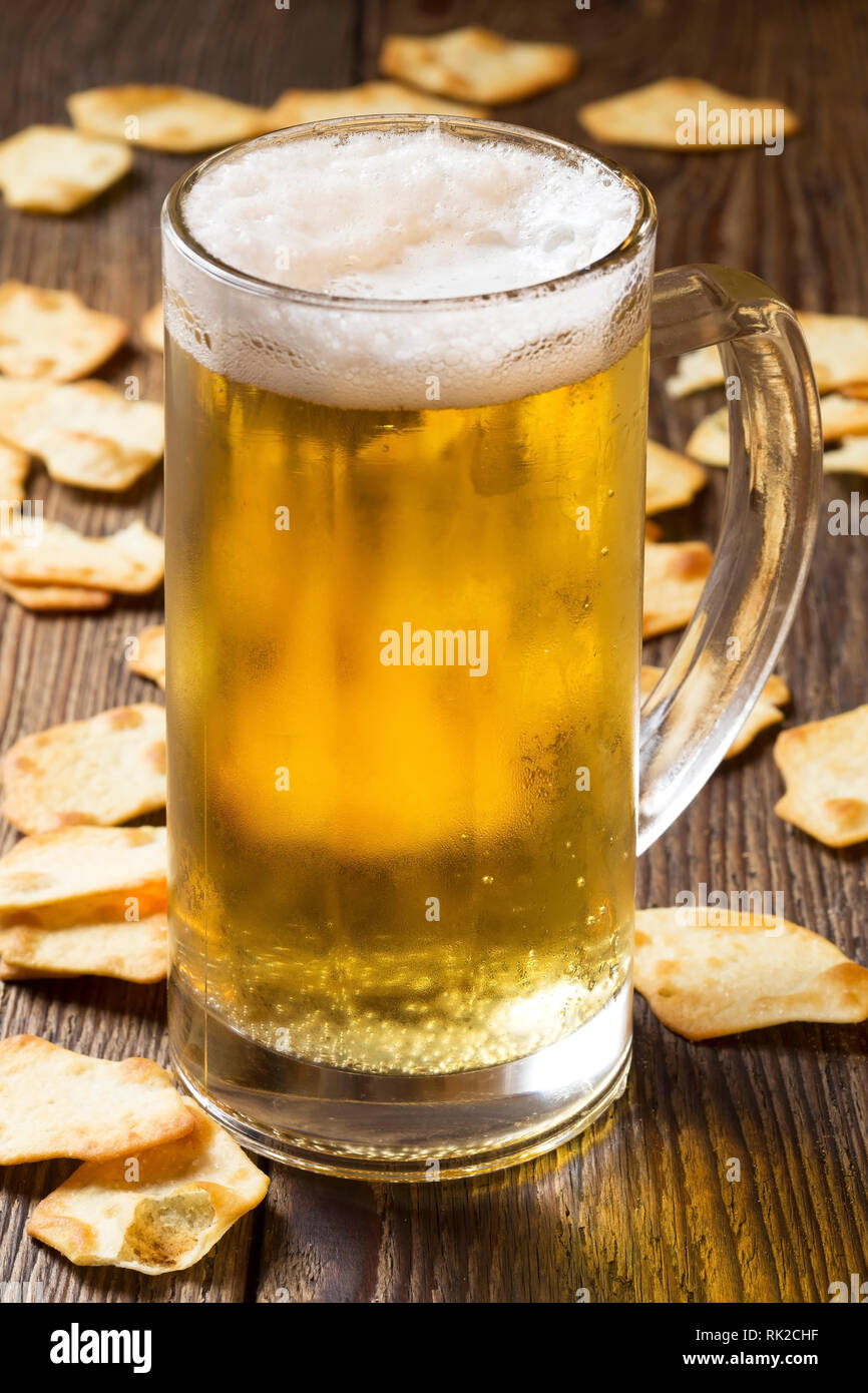 Mug of beer and crackers on wooden background Stock Photo