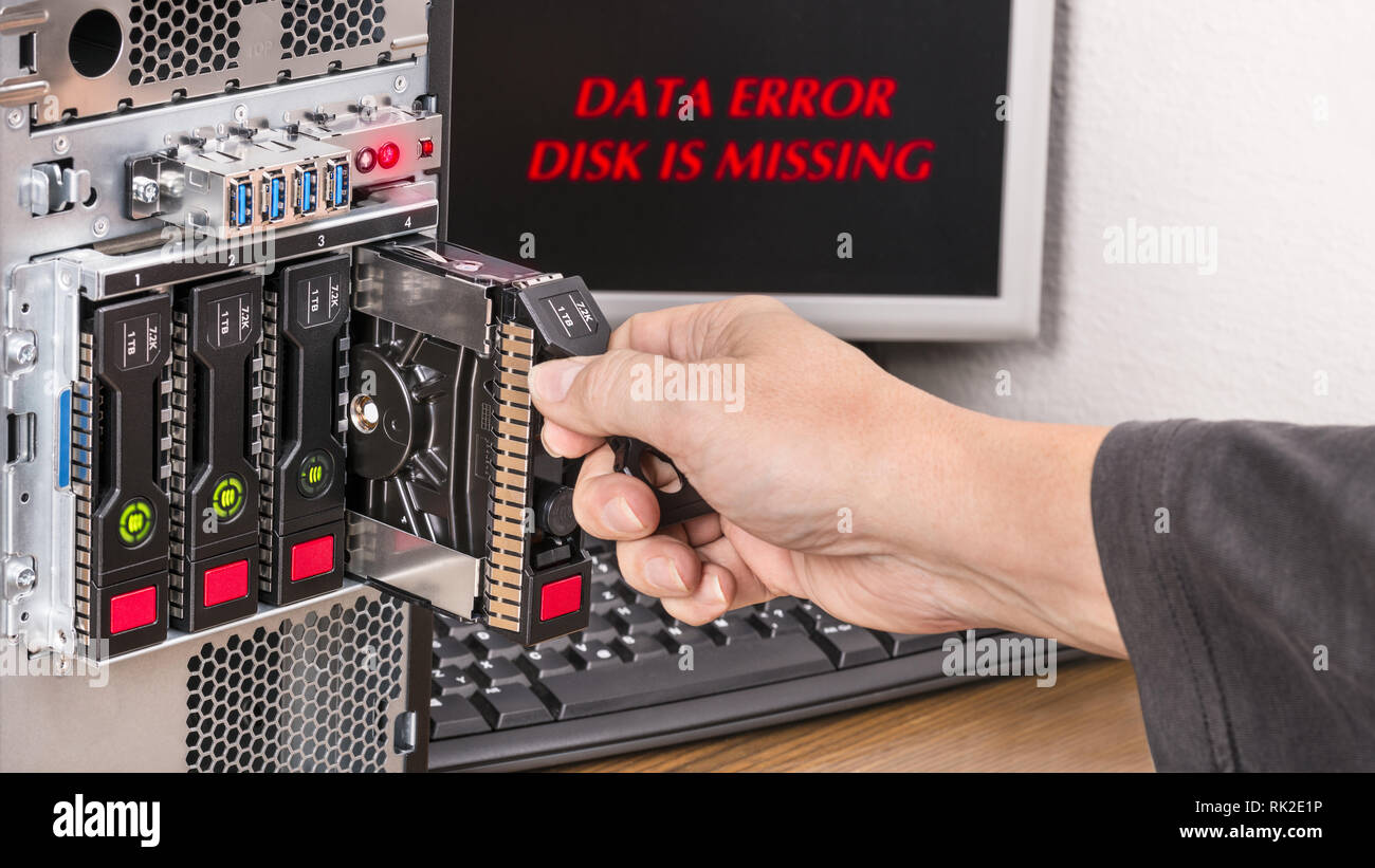 Server hot-swap hard disks and human hand. Red messages data error and disk is missing on a black desktop. Technical support. Security and protection. Stock Photo