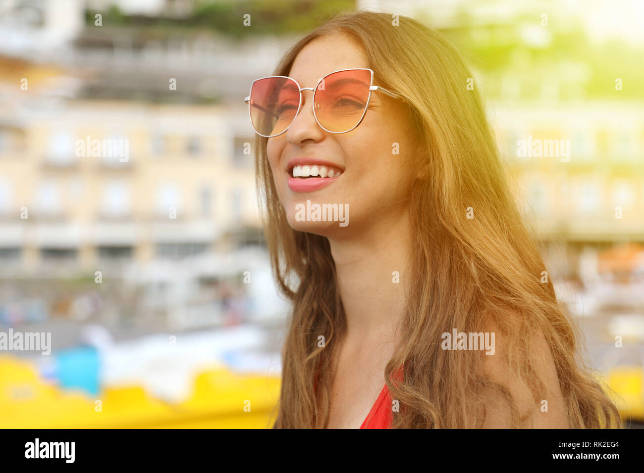 Portrait of a smiling woman wearing sunglasses at Positano beach ...