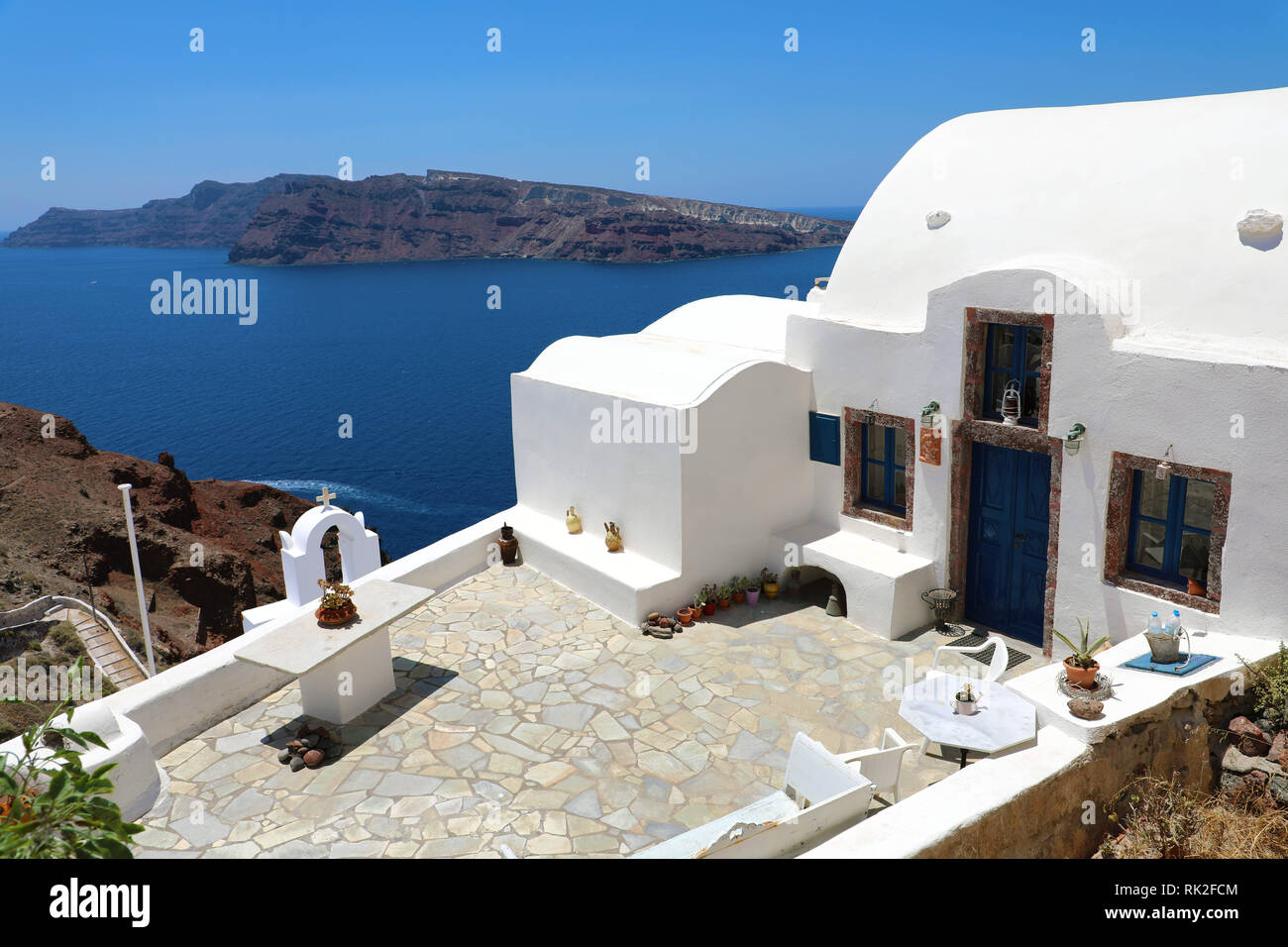 Greek house with terrace and sea view. White architecture on Santorini island, Greece. Beautiful summer landscape. Stock Photo