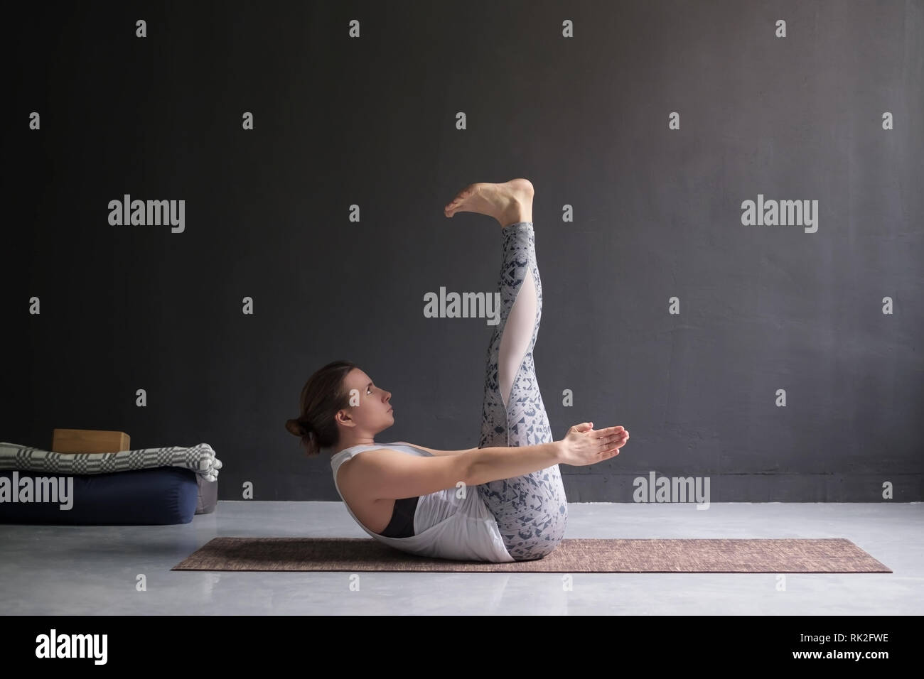 Young woman practicing yoga asana Ardha Navasana Stock Photo