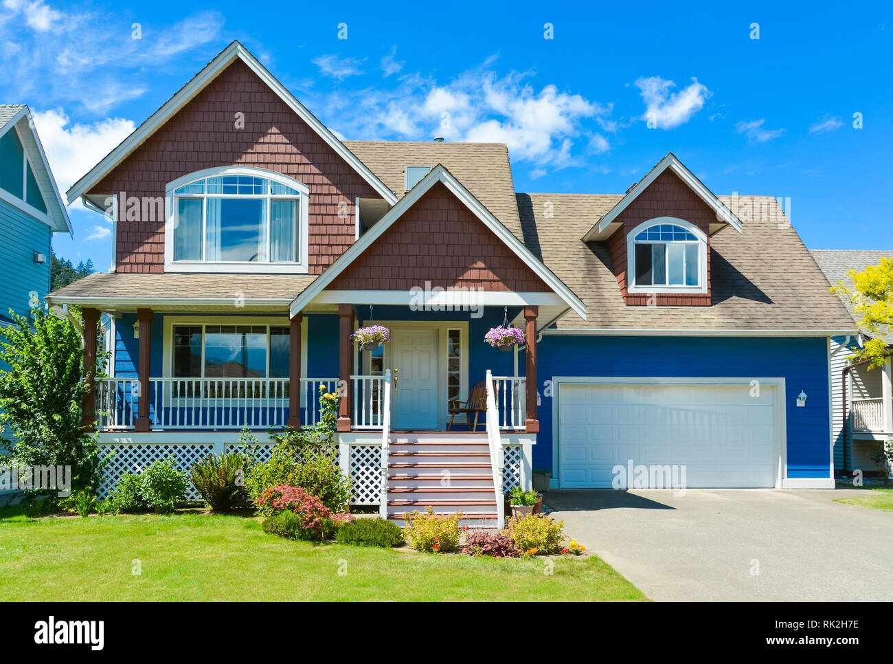 Blue Residential House With Concrete Driveway In Front And Blue