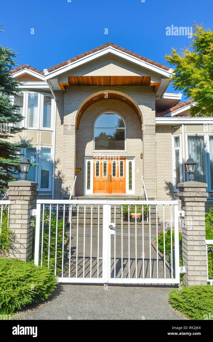 Entrance of luxury family house with white gates in front. Vancouver, Canada Stock Photo