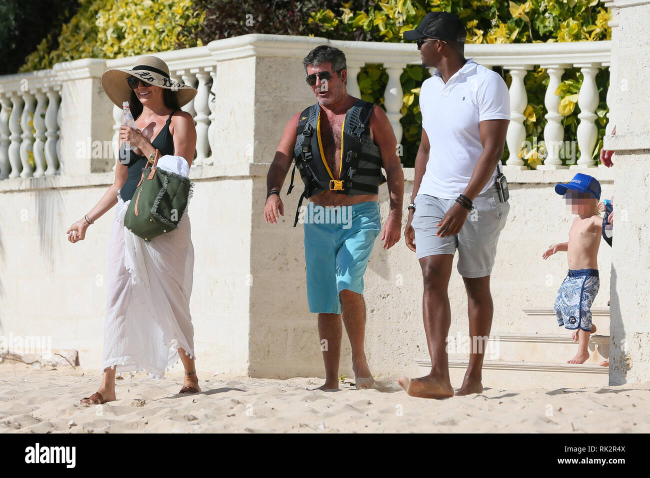 Simon Cowell, Lauren Silverman, and their son Eric board a boat during