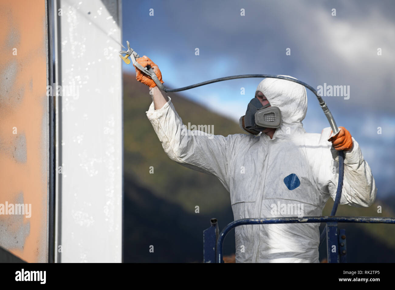 Tradesman spray paints the steel beams on a construction site Stock Photo