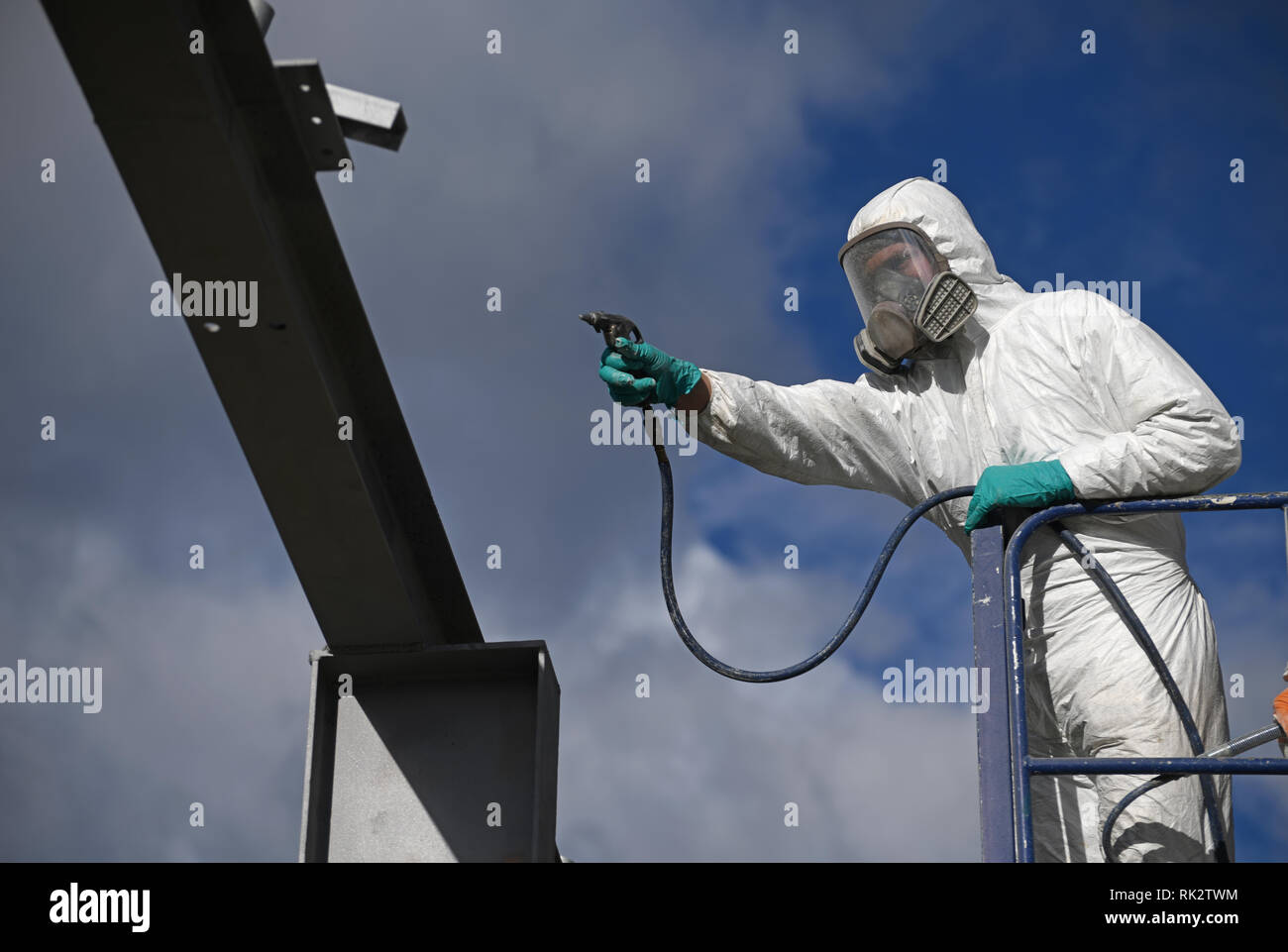 Tradesman spray paints the steel beams on a construction site Stock Photo