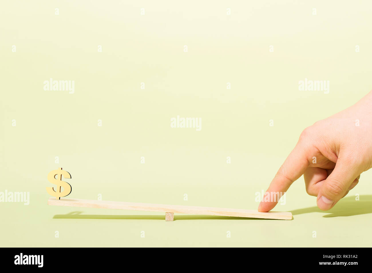 Dollar economy with seesaw, finger Stock Photo