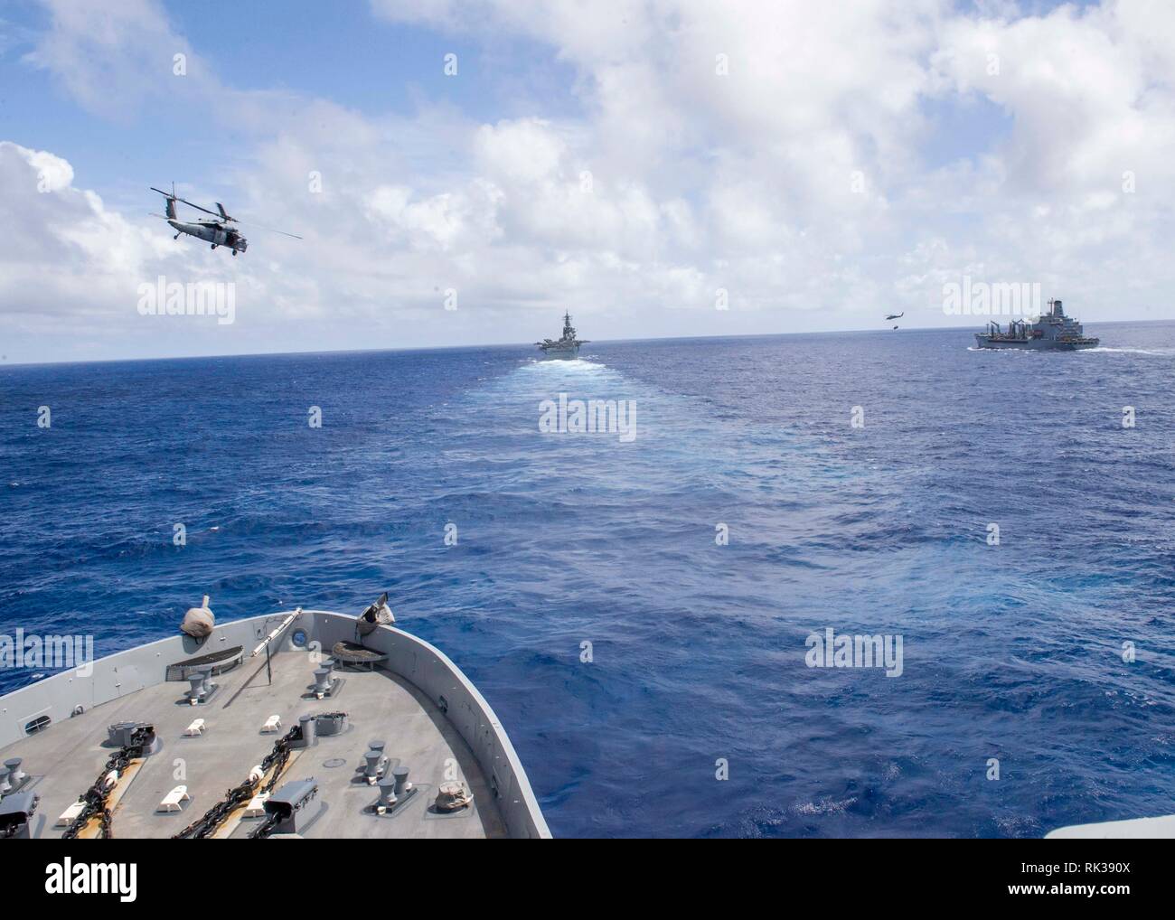 190207-N-PH222-1232 PACIFIC OCEAN (Feb. 7, 2019) The San Antonio-class amphibious transport dock ship USS Anchorage (LPD 23), left, participates in a vertical replenishment with fleet replenishment oiler USNS Pecos (T-AO 197), right, and the Wasp-class amphibious assault ship USS Essex (LHD 2) during a deployment of the Essex Amphibious Ready Group (ARG) and 13th Marine Expeditionary Unit (MEU). The Essex ARG/13th MEU is a capable and lethal Navy-Marine Corps team deployed to the 7th fleet area of operations to support regional stability, reassure partners and allies and maintain a presence po Stock Photo