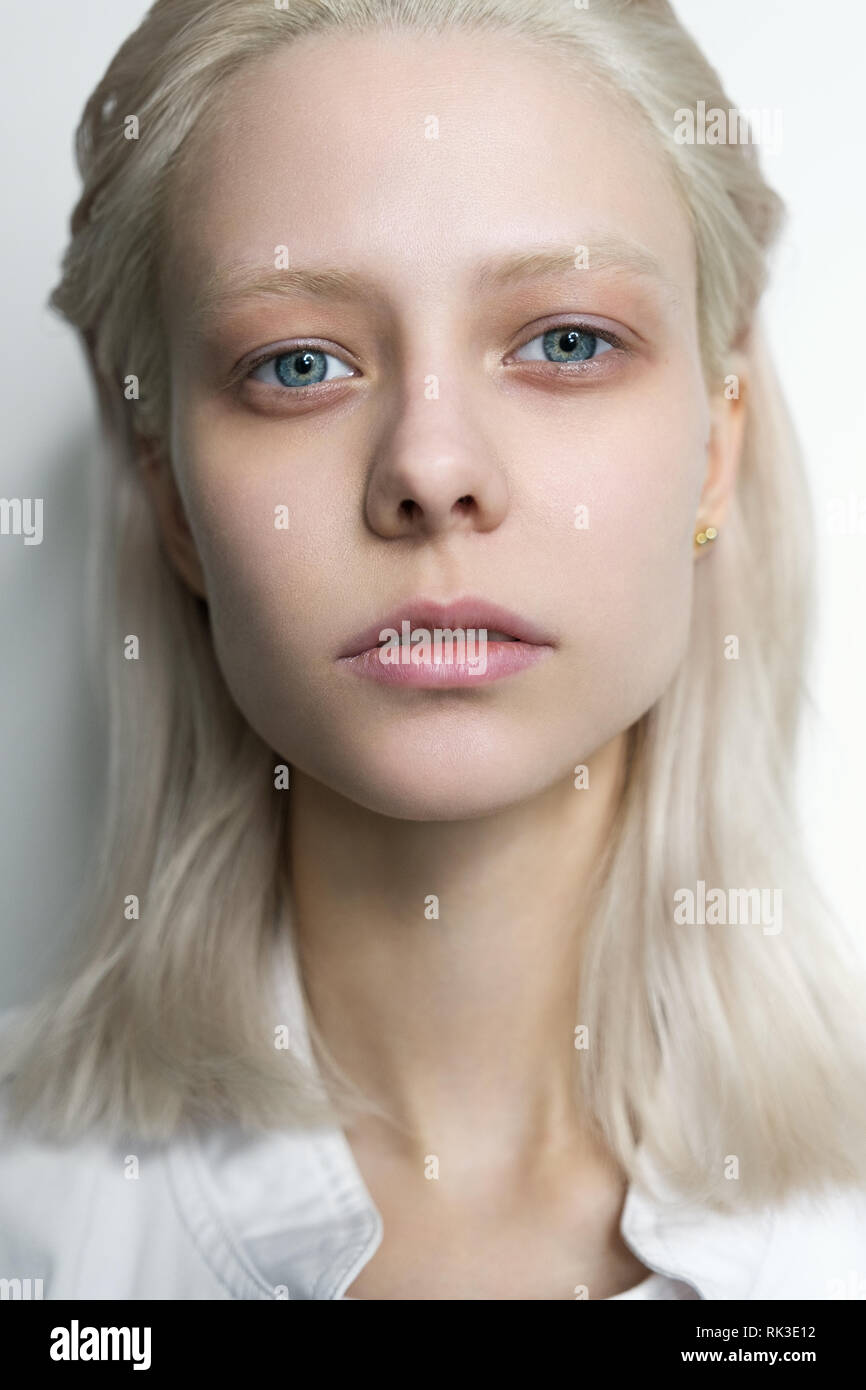 Portrait of a blonde girl with blue eyes without makeup on a light  background. Close horizontal photo Stock Photo - Alamy