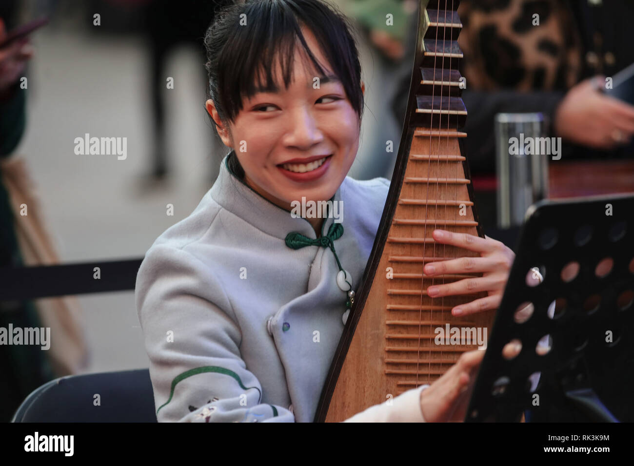 A chinese woman seen playing a traditional Chinese musical instrument during the Chinese New Year celebration. The Chinese community and Chinese officials of Madrid joins the festivities in this fifth edition of the celebration of the Chinese New Year, year of the pig in the neighborhood along with multiple activities organized by the Embassy of the People's Republic of China and the Culture and Sports Area of the Madrid City Council. Stock Photo