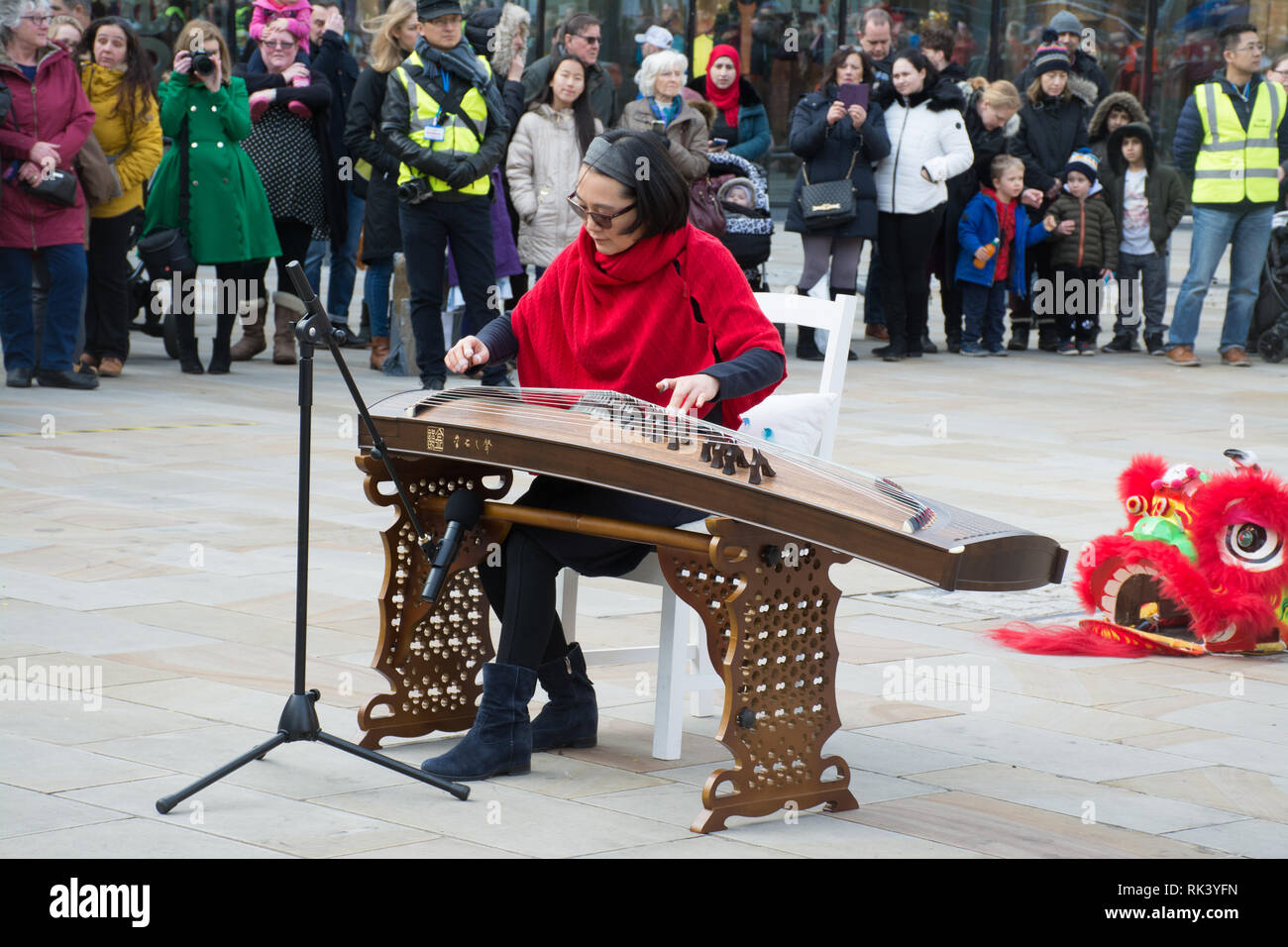 Woking, Surrey, UK. 9th February, 2019. Woking town centre celebrated the Chinese New Year of the Pig today with colourful parades and shows. A solo musical performance on the Chinese zither or guzheng. Stock Photo