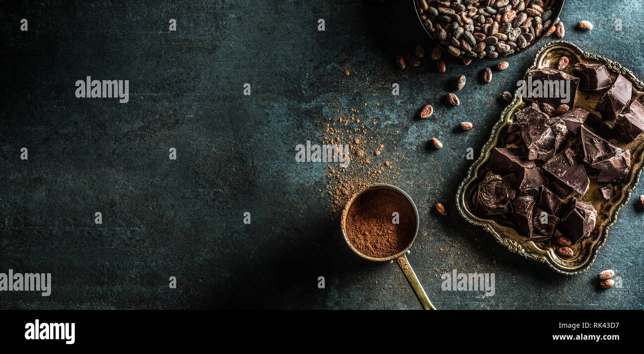 Dark chokolate cocoa beans and powder on concrete table Stock Photo