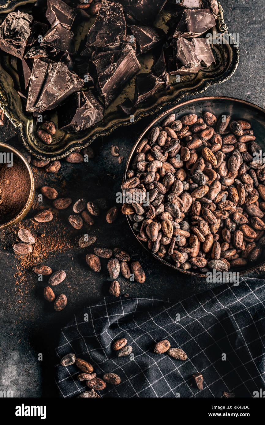 Dark chokolate cocoa beans and powder on concrete table Stock Photo