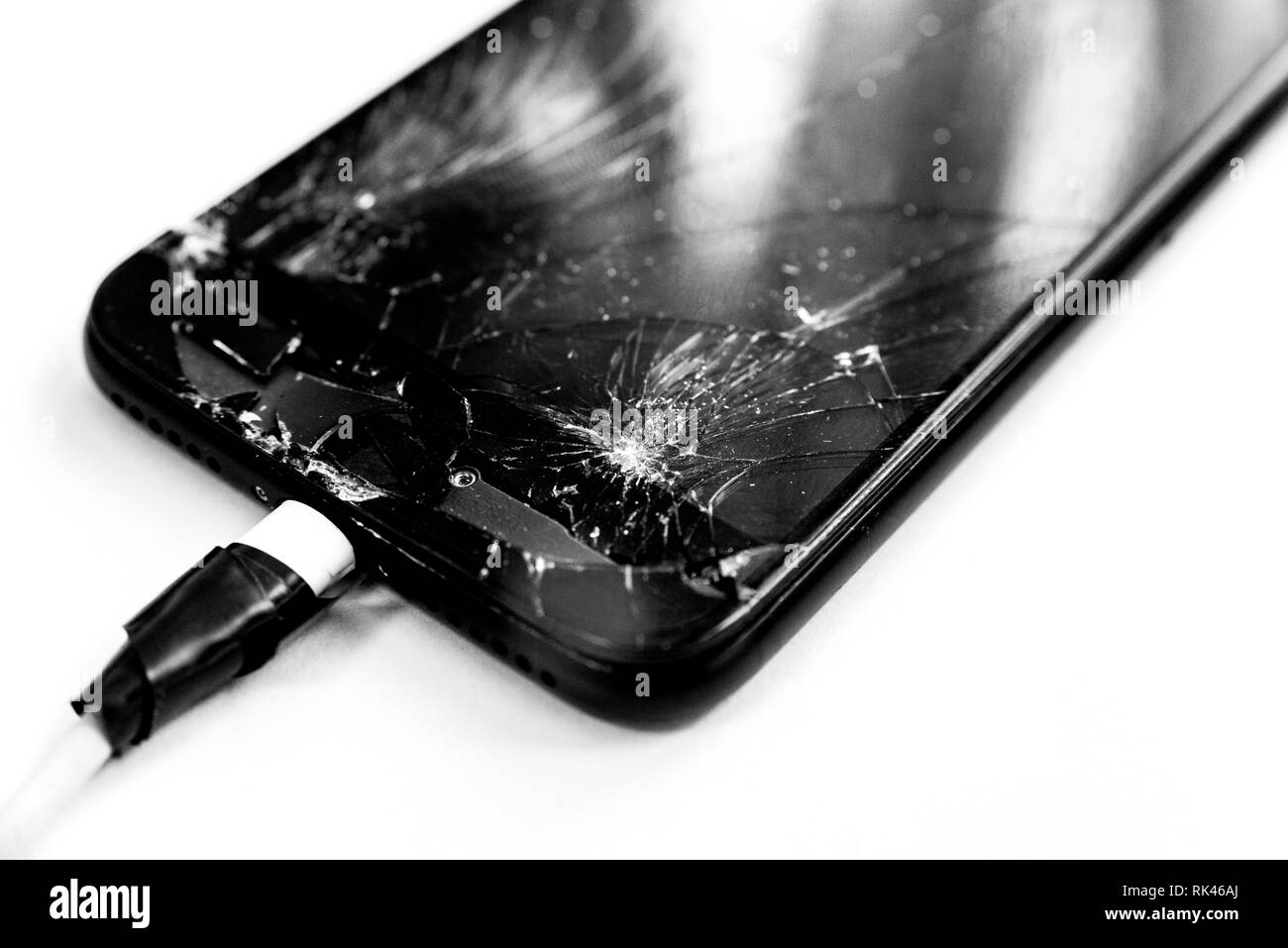 Cell phone with the screen broken by a hammer. non-warranty repairs concept. Stock Photo